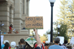 Somone holds up a Public Lands = Wyoming Heritage sign at a rally in Cheyenne