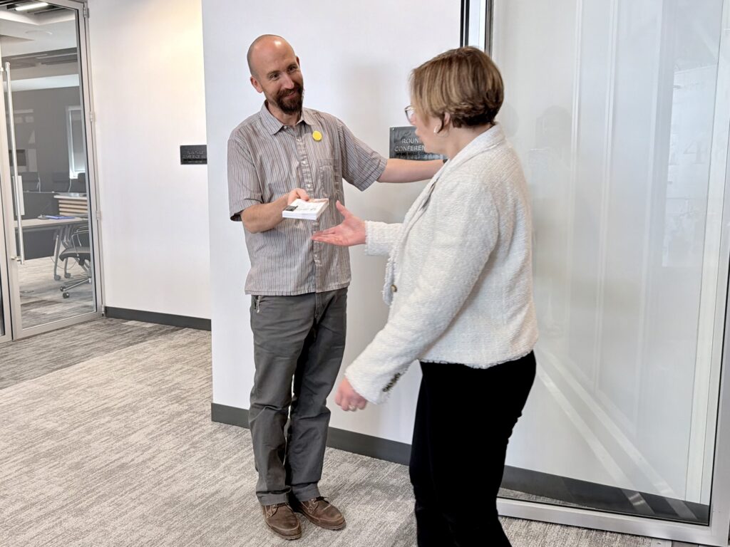 Better Wyoming Director, Nate Martin, passes off over 50 postcards to Sen. Evie Brennan. All of these postcards were signed by voters in her district.